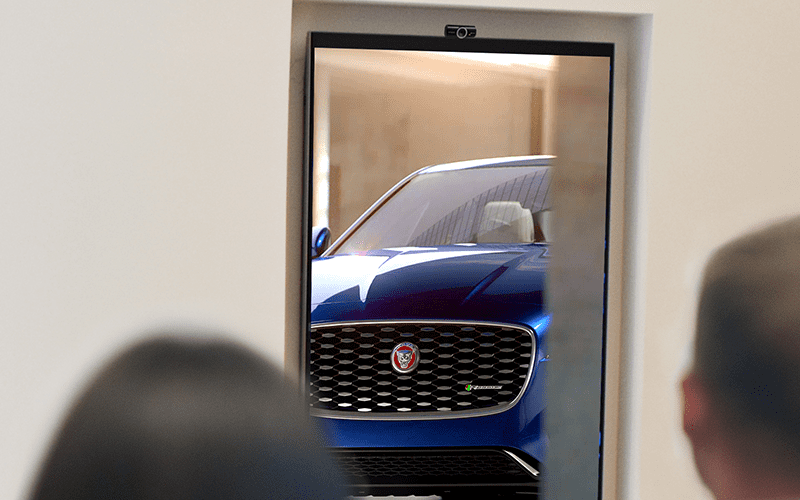 People looking at digital signage screen fitted with a camera